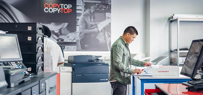 Employé COPYTOP vérifiant la qualité d'un document imprimé