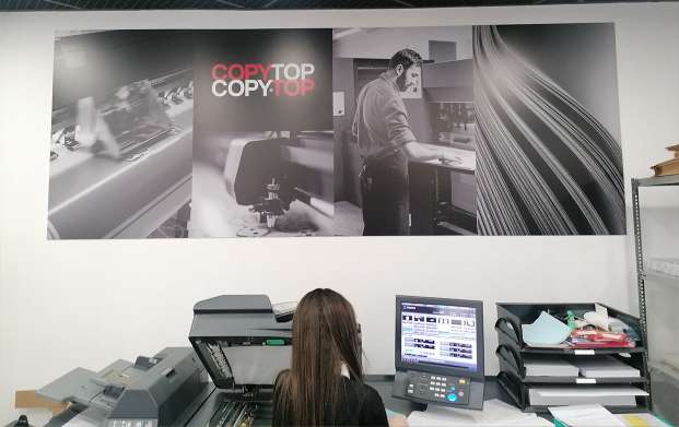 Conseillere utilisant le copieur noir et blanc de l'agence COPYTOP Saint Lazare - Rome à Paris