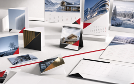 Collection de cartes de vœux personnalisées et de calendriers imprimés (calendriers muraux, calendriers de bureau et calendriers chevalets) présentés dans un décor soigné, illustrant des supports de communication personnalisables.