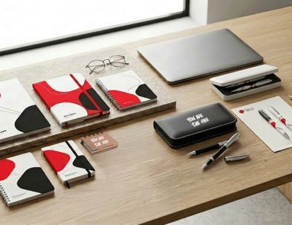 Décor de bureau présentant une gamme complète de papeterie de bureau personnalisée : carnets, blocs-notes, papier à en-tête, enveloppes, chemises, sous-mains et autres fournitures imprimées aux couleurs de l'entreprise.