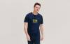 Un homme porte un T-shirt de sport bleu marine avec un visuel publicitaire imprimé au centre de la poitrine.