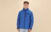 Homme portant une veste softshell bleue zippée, personnalisée avec un logo multicolore sur la poitrine gauche