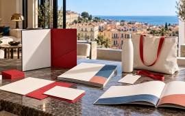Flyers, cartes, brochures, dossier relié, badge et gourde personnalisée dans un bureau lumineux avec vue sur les toits de Montpellier.