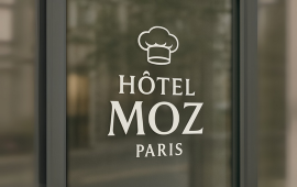 Adhésif avec nom et logo appliqué sur la vitrine d'un commerce.