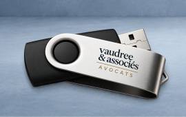 Clé USB noire et argentée avec le logo d'un cabinet d'avocats, idéale pour transporter et partager des documents professionnels.